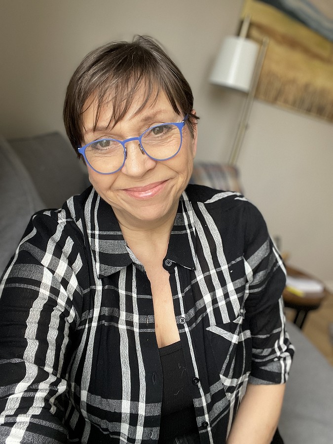 A compassionate woman with a warm smile, reflecting her extensive experience and deep empathy as an Addiction Recovery Coach