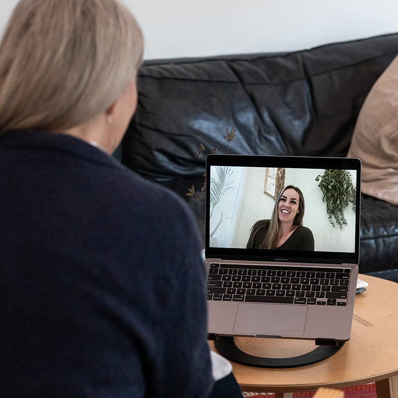 A woman taking part in a confidential 1-on-1 meeting with a Sober Recovery Coach from her own home using video chat